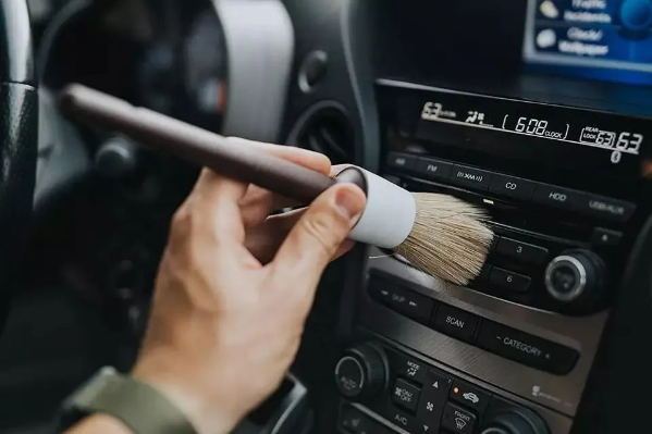 Cleaning car air outlet with animal hair detailing brush